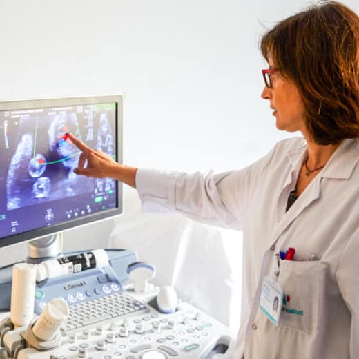 A doctor pointing to a screen in the hospital.