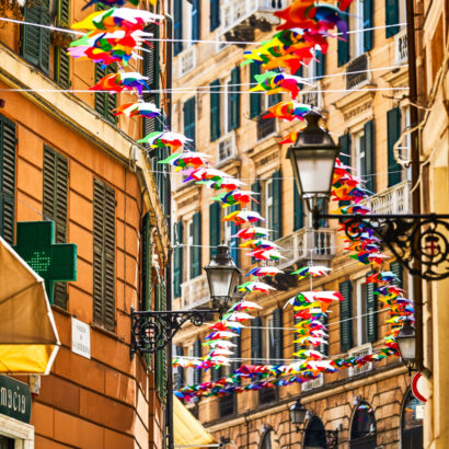 A view of a street with decorations suspended above the walkway.
